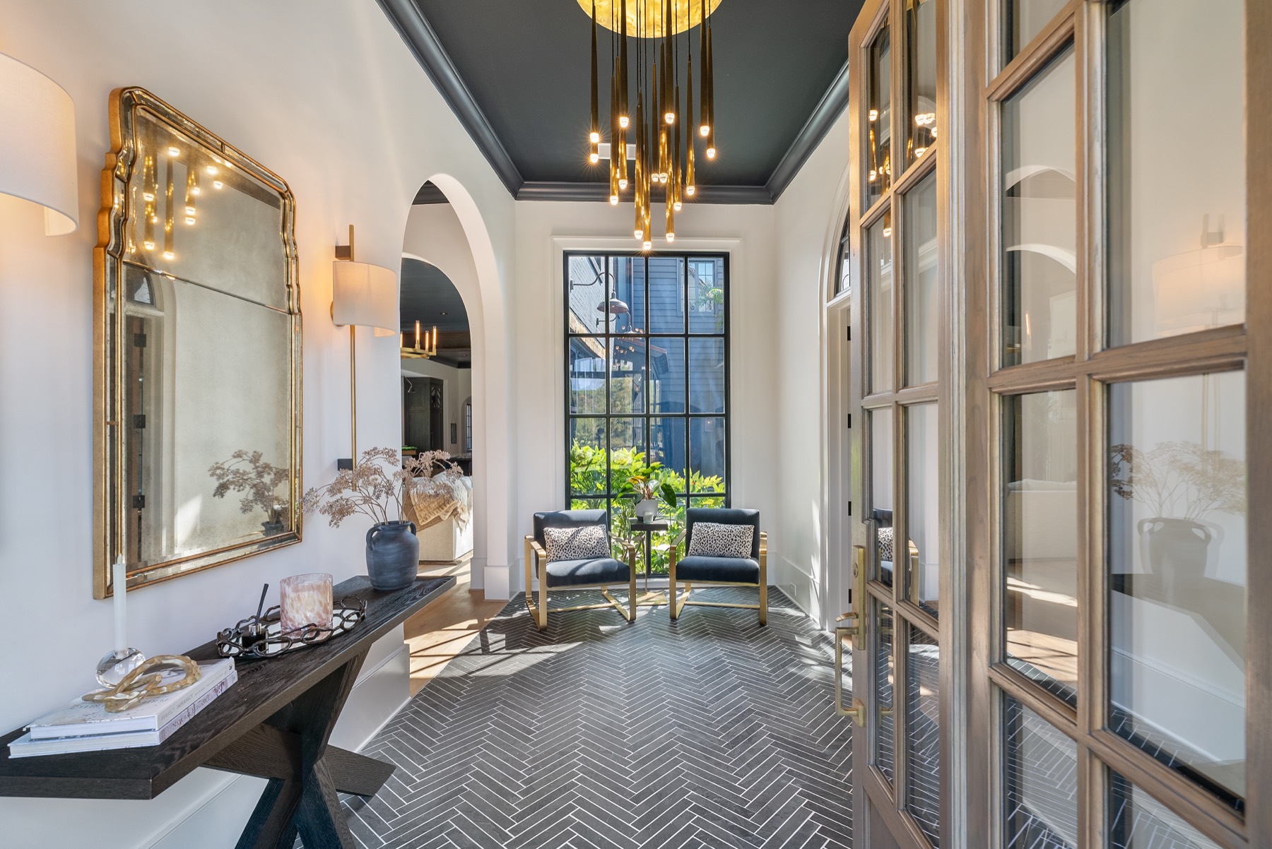 Elegant entryway with herringbone tile floor and brass chandelier