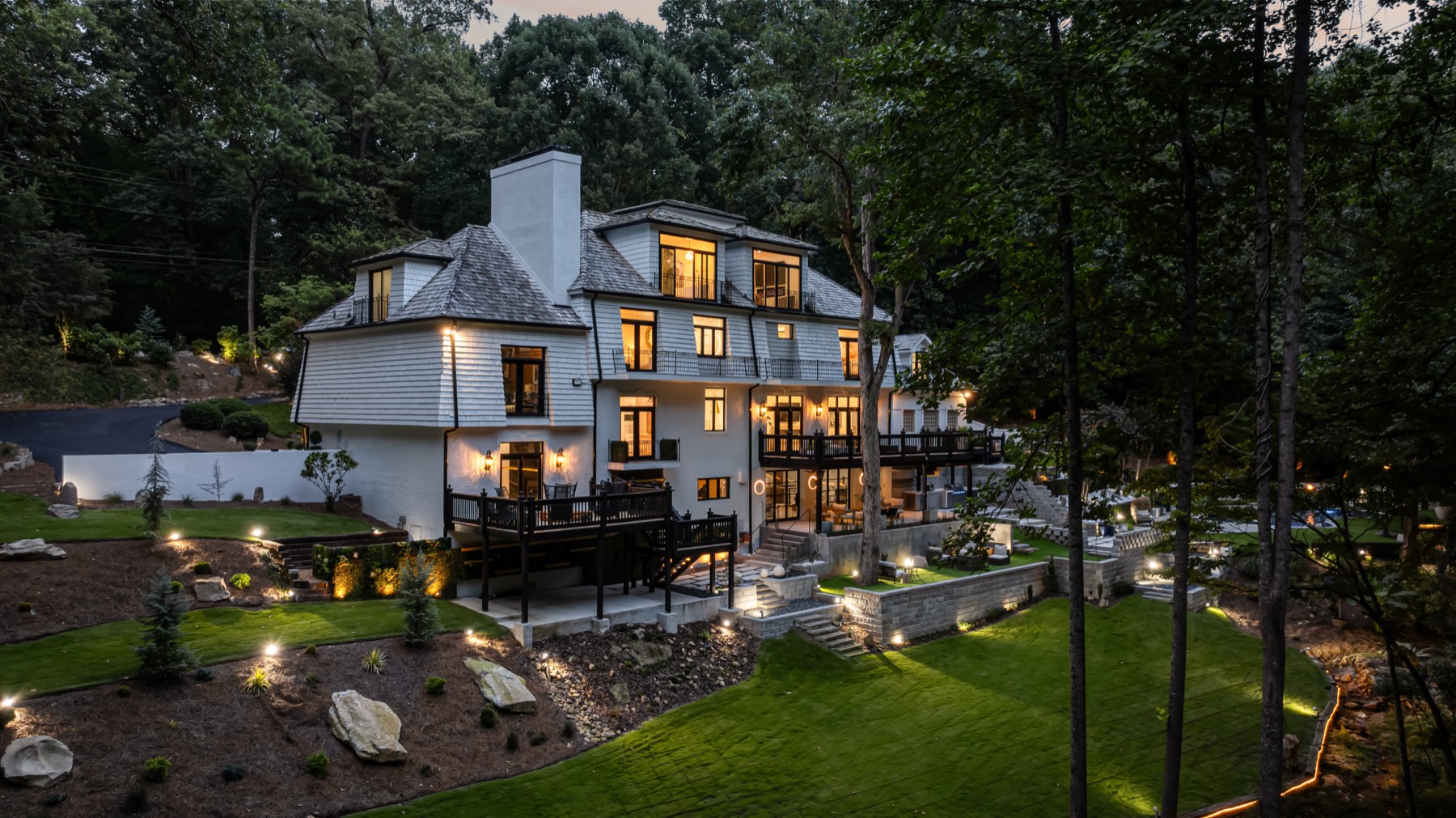 Multi-story shingle-style Atlanta home exterior lit up at twilight