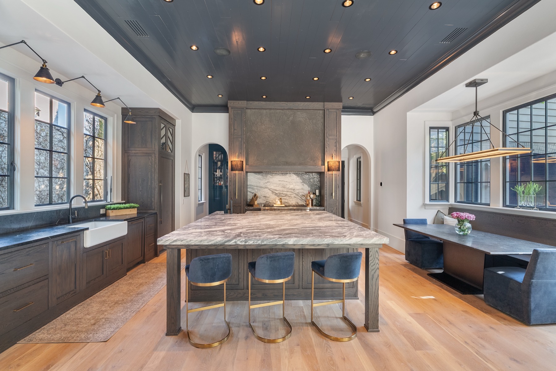 Moody kitchen with black shiplap ceiling and marble waterfall island