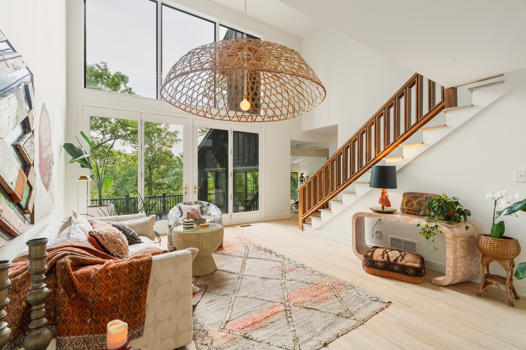 Two-story living room with statement woven pendant light and eclectic decor