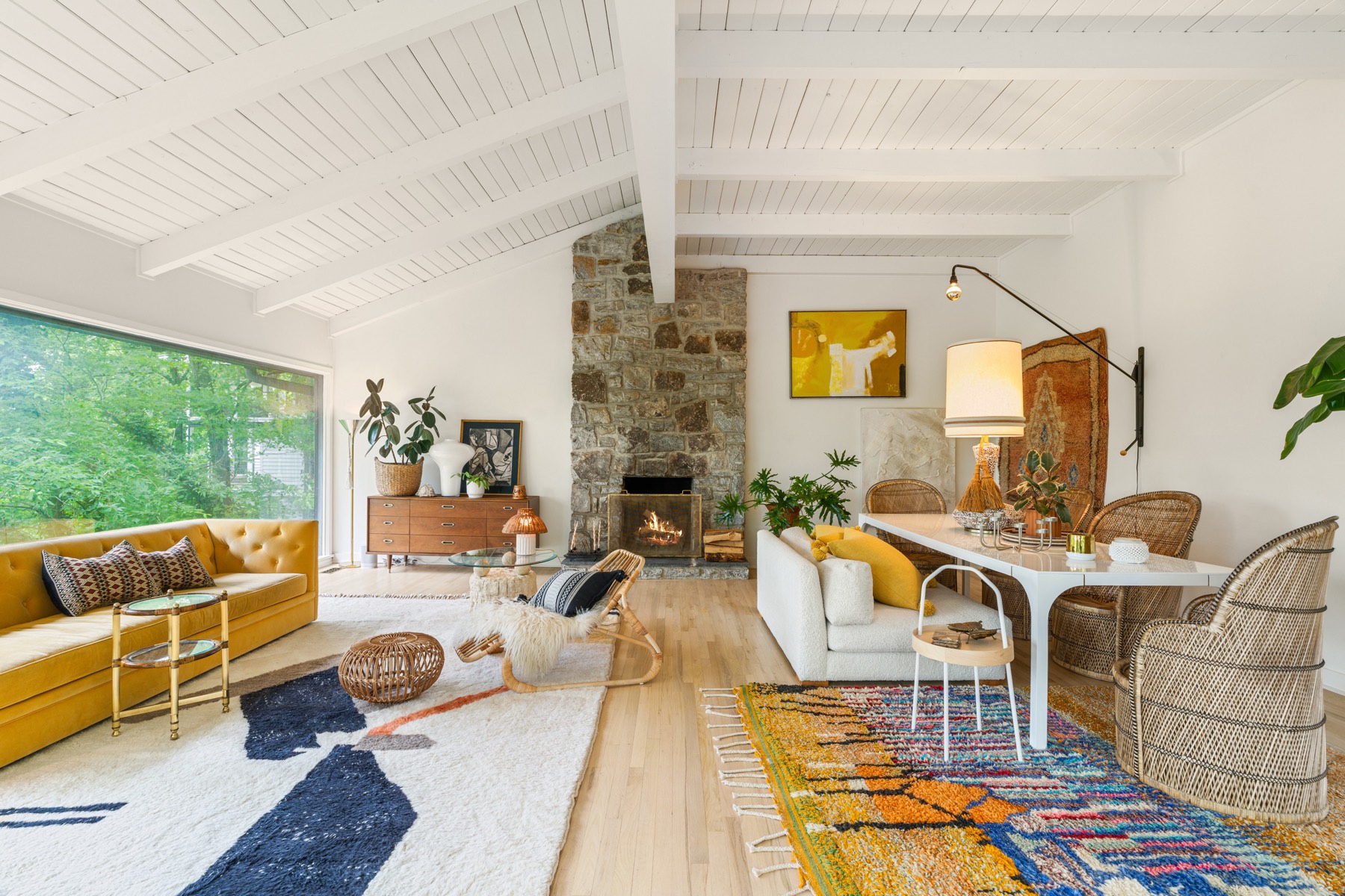 Mid-century modern living room with mustard velvet sofa and stone fireplace
