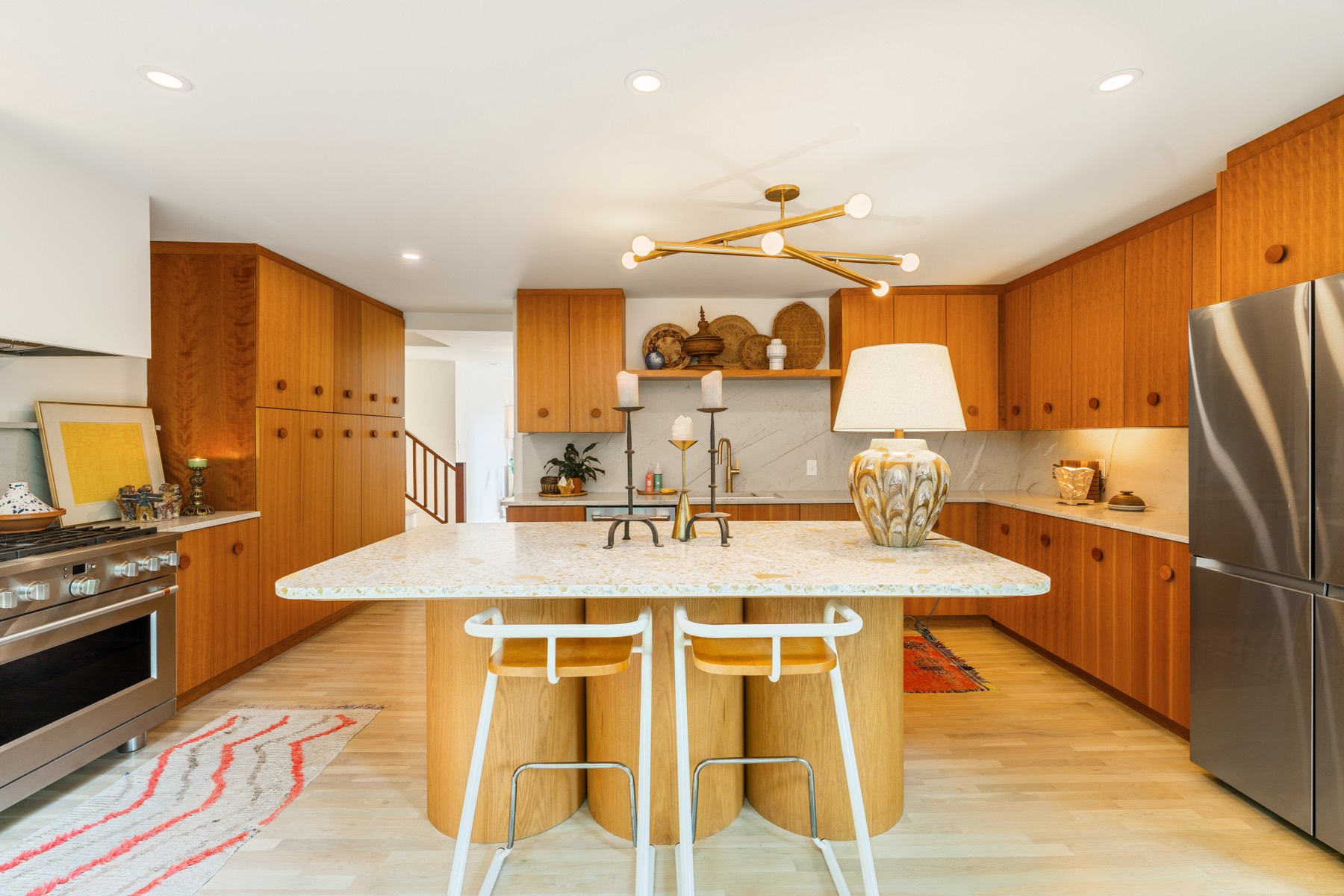 Retro-inspired kitchen with terrazzo island and warm wood cabinetry