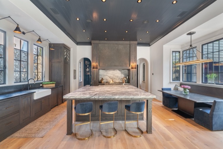 Moody kitchen with black shiplap ceiling and marble waterfall island